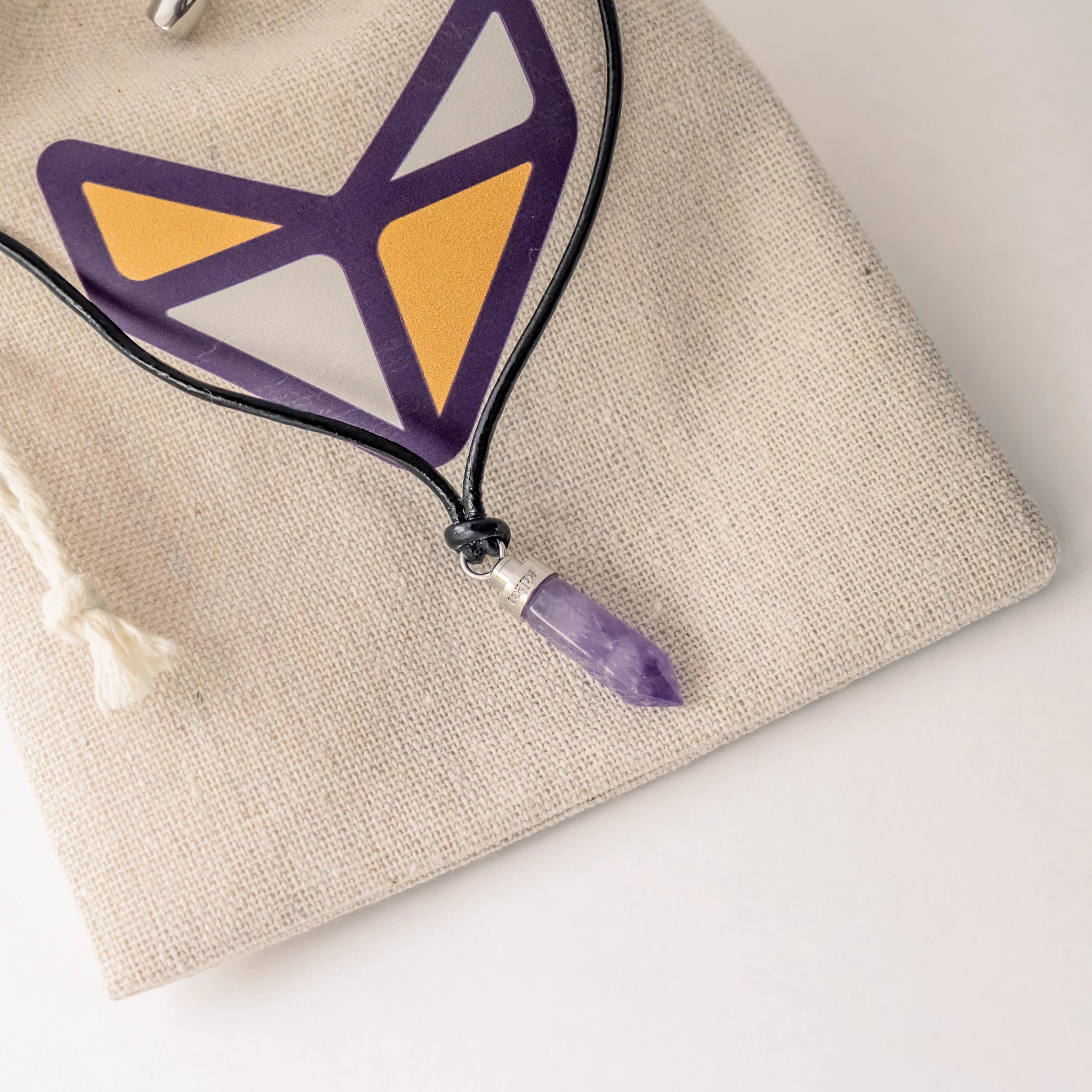 Amethyst calm pendant resting on Teaps linen pouch
