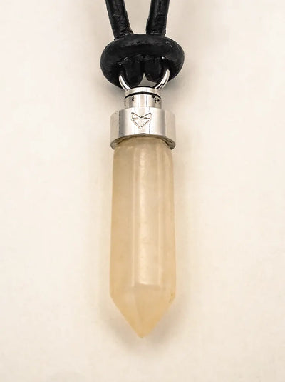 Close-up of citrine joy pendant on black leather cord on a beige background